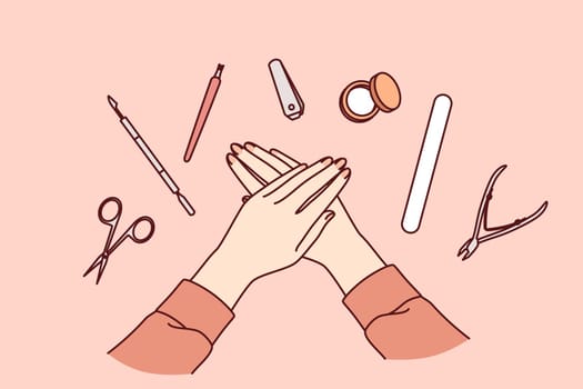 Tools for manicure around hands of woman with nails in need of polishing or removing cuticles. Manicure set with nail file and small scissors for self-care of your fingers without trip to beauty salon
