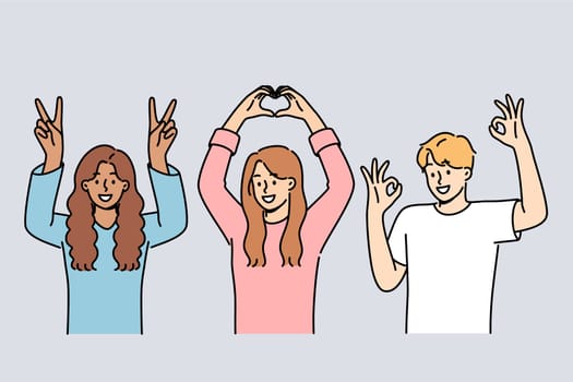 Multiethnic people students smiling showing approval gestures and raising hands up. Happy guy and two students girls rejoice at having multiracial friends and lack of discrimination in society