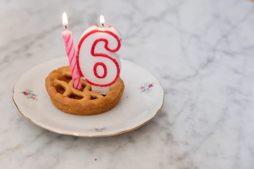 Birthday tart with 16 candles on background