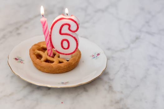Birthday tart with 16 candles on background