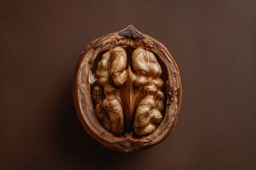 An isolated walnut half reveals its intricate texture against a brown background.