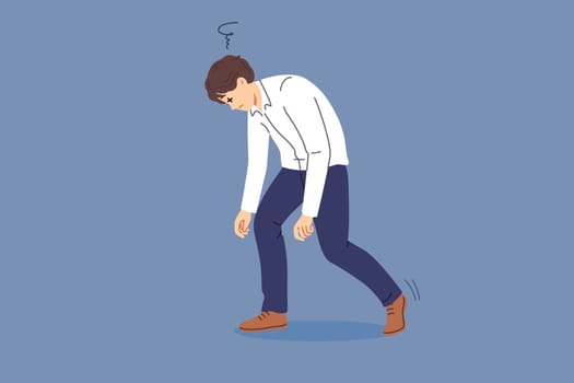 Tired man bends over and closes eyes due to exhaustion caused by overwork and overload. Business guy feels drowsy and exhaustion after completing difficult job on behalf of manager.