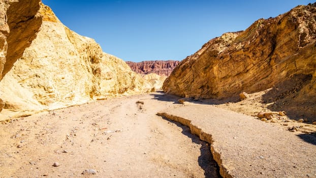 Hiking trail through the Golden Canyon with the view of Red Cathedral rock formations in Death Vallley National Park in California