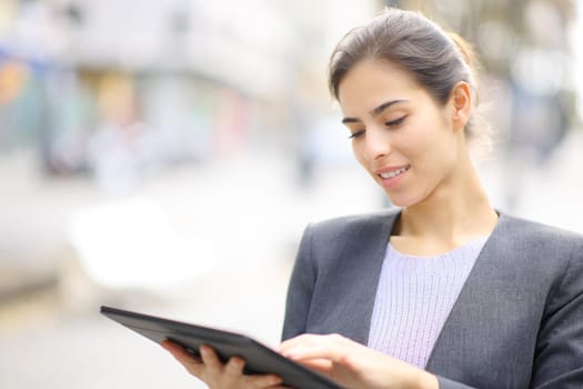 Executive using tablet standing in the street