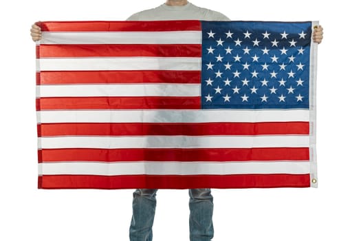 Anonymous individual displays a large united states flag, symbolizing patriotism and national pride