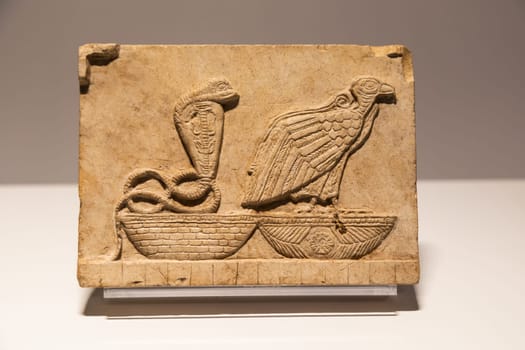 Turin, Italy - 28 December 2023: Egyptian Museum. Plaque with vulture and cobra, limestone, 400 BC