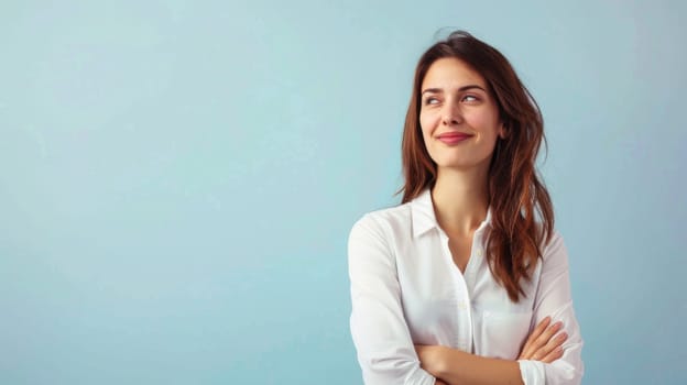 A woman wearing a white shirt strikes a pose for a photograph. She stands confidently, smiling at the camera, showcasing her outfit. The background is simple, drawing attention to her.