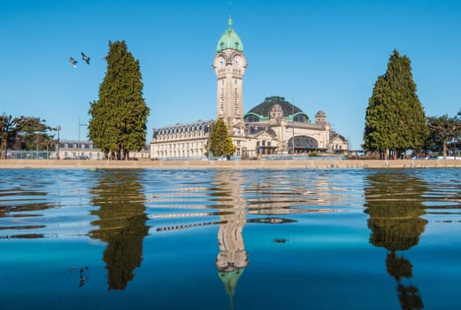 Limoges, France - April 04 2023: View of the famous Limoges station called Limoges-Bénédictins, in France. One of the city's most emblematic buildings. fountains In the foreground