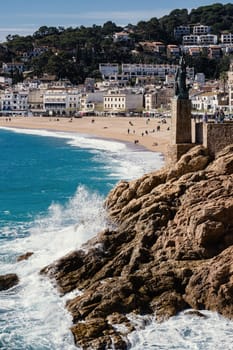 A glimpse of the beach at Tossa de Mar near the statue dedicated to the Goddess Minerva. Costa Brava in Catalonia, Mediterranean Sea, Spain.