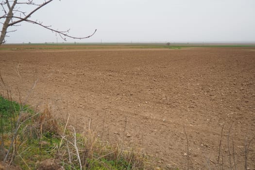 A tractor-plowed field in Chalma, Serbia. Agribusiness. Agricultural land. Fertile black soil. Row of furrows in a plowed field prepared for planting crops in the spring. Horizontal perspective view