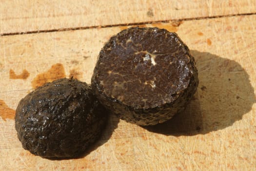 Tomato and black truffle isolated on a wooden cutting board