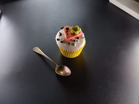 A delicious cupcake with heart on a black backround