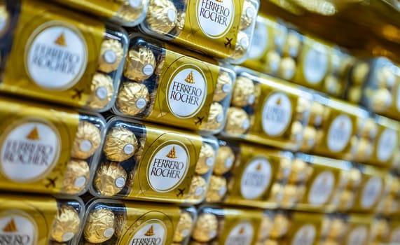 DUBAI, UAE - MAR 06, 2024: Boxes of Ferrero Rocher premium chocolate sweets put up for sale in the store at Dubai International Airport