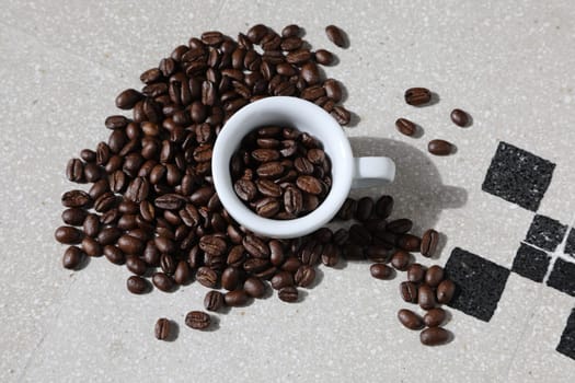 Close up of a cup of black coffee grains ad a cup
