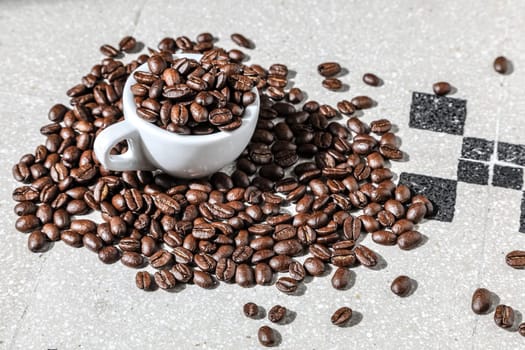 Close up of a cup of black coffee grains ad a cup