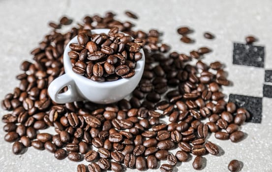 Close up of a cup of black coffee grains ad a cup