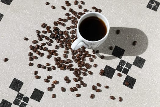 Close up of a cup of black coffee grains ad a cup