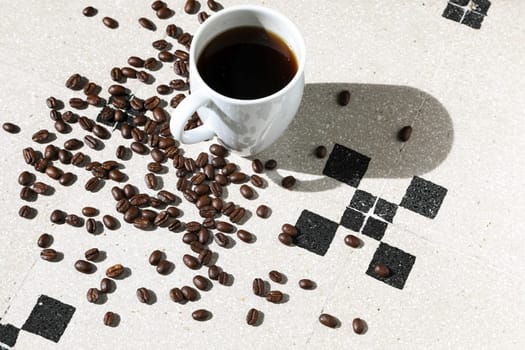 Close up of a cup of black coffee grains ad a cup