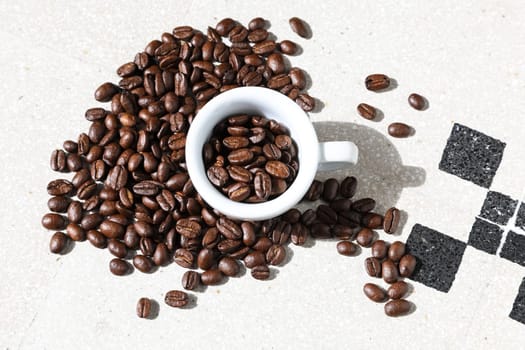 Close up of a cup of black coffee grains ad a cup