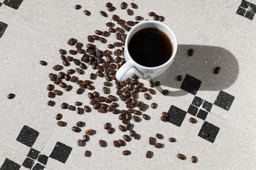 Close up of a cup of black coffee grains ad a cup