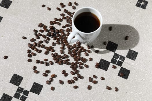 Close up of a cup of black coffee grains ad a cup