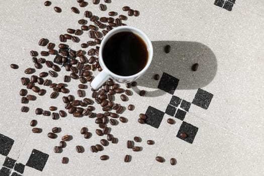 Close up of a cup of black coffee grains ad a cup