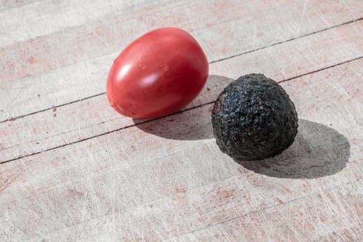 Tomato and black truffle isolated on a wooden cutting board
