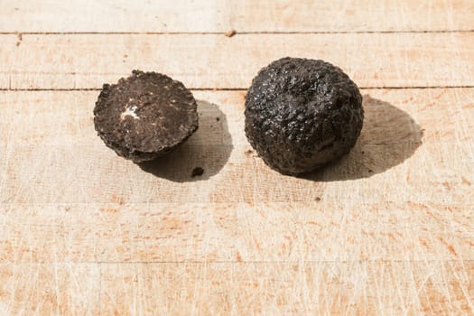 Tomato and black truffle isolated on a wooden cutting board