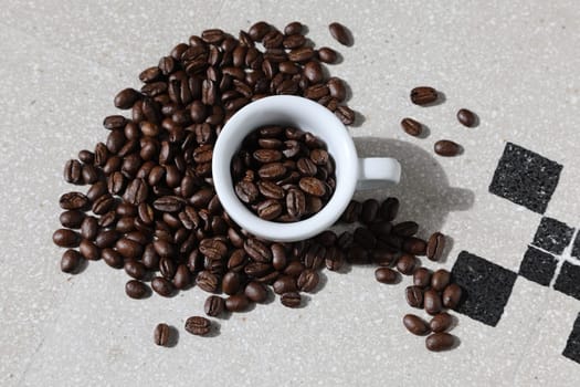 Close up of a cup of black coffee grains ad a cup