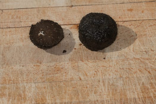 Tomato and black truffle isolated on a wooden cutting board