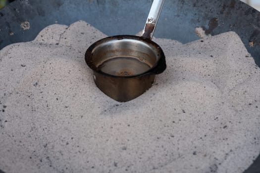 Preparation of desert arabic coffee on hot sand