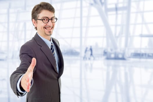 businessman in suit offering to shake the hand, at the office
