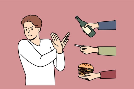 Man gives up bad habits, making forbidden gesture near hands with alcohol and cigarettes or fast food. Guy says stop bad habits to start healthy lifestyle and avoid loss of immunity