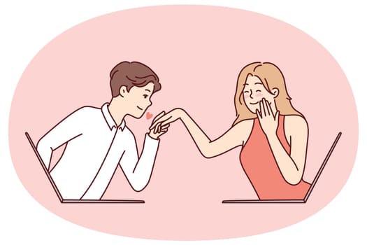 Determined guy kisses hand of embarrassed girl looking out of laptop screen. Metaphor of online dating and flirting in email correspondence or remote rendezvous lovers