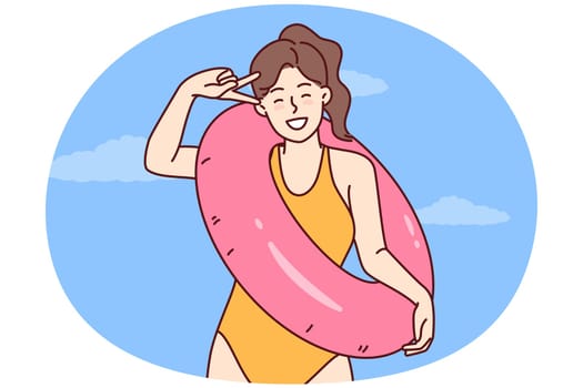 Happy woman in swimsuit for sunbathing and swimming in ocean rejoices in long-awaited summer vacation and holds lifebuoy. Girl tourist in bathing suit for beach or pool is resting on tropical island