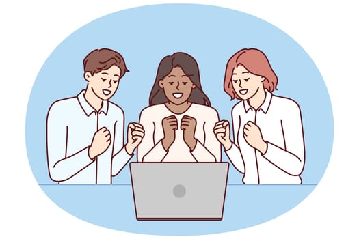 Team of excited friends sitting near laptop and watching football match together. Team of man and two girls watch video broadcast and clench fists, wanting to hear important news via video link