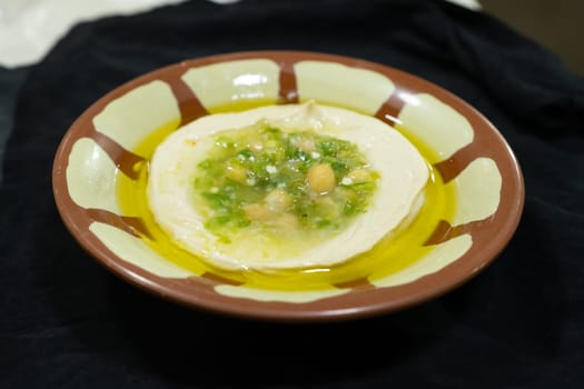 Hummus , sauce made from chickpea paste and sesame seed paste flavored with olive oil, garlic, lemon and paprika juice, cumin seed powder and finely chopped parsley.