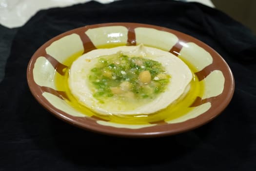 Hummus , sauce made from chickpea paste and sesame seed paste flavored with olive oil, garlic, lemon and paprika juice, cumin seed powder and finely chopped parsley.