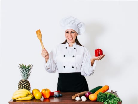 Woman chef holding a ladle on a table with vegetables, A smiling woman chef holding a ladle and vegetables, portrait of a woman chef holding a ladle on isolated background