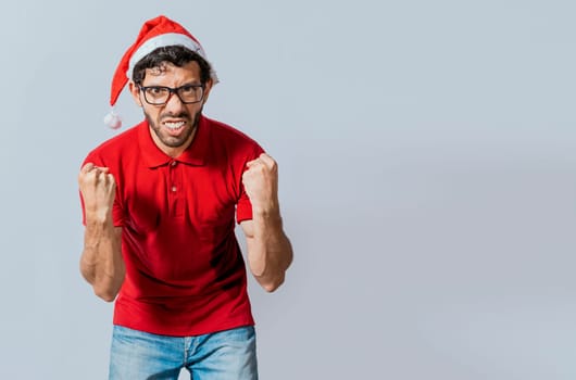 Man with beard and christmas hat angry looking at camera isolated. Furious christmas man looking at camera. People in christmas hats angry and furious looking at the camera.