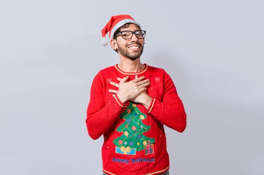 Thankful people in christmas clothes smiling with hands on chest. Man in christmas hat with sincere lovely smile feeling thankful, Smiling guy in christmas hat making thank you gesture