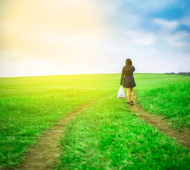 woman walking in the field with shopping bags, woman walking on a road in the field