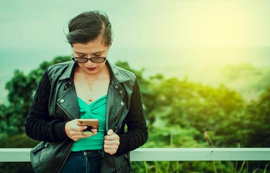 Latin woman checking her cell phone, pretty girl in glasses checking her cell phone