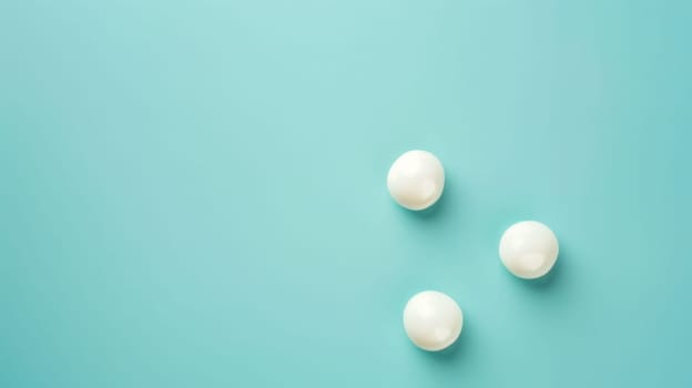 Three white pills are arranged neatly on a bright blue background, creating a simple and clean composition. The pills are round and smooth, with a glossy finish.