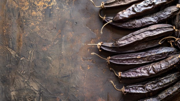 A grouping of brown peppers is arranged neatly on top of a wooden table. Each pepper varies in size and shape, showcasing their natural colors. The peppers appear fresh and ready for use in cooking or as a flavorful garnish.