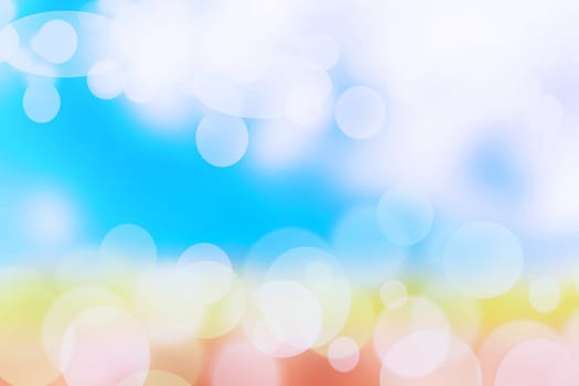Abstract bright gradient motion spring or summer landscape texture background with natural orange yellow bokeh lights and blue bright sunny sky. Beautiful backdrop with space for design.