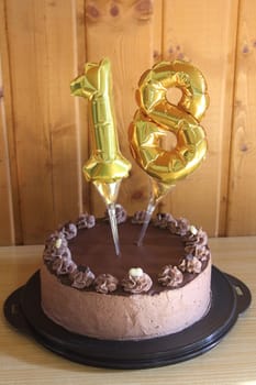 A round chocolate cake with embellishments and an inscription