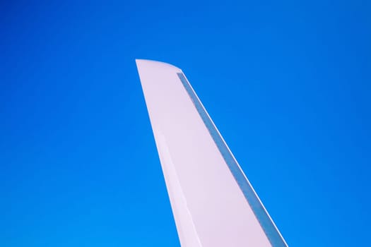 View at the part of a wing of the airplane or airliner during the flight from the window with blue sky and without clouds.Wing of aircraft. Copy space.