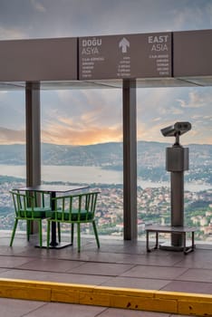Tower Optical coin-operated binocular on the observation deck of Istanbul Sapphire,Turkey, against cityscape before sunset with sign including distances to some Asian capital cities to the east