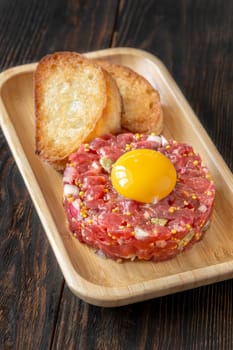 Portion of Beef steak tartare topped with a raw egg yolk